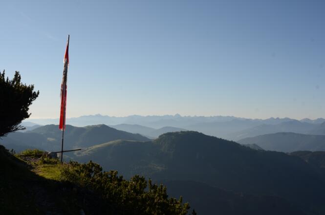 Die Fahne der Werfener Hütte ziert den Blick zur Hochalmspitze