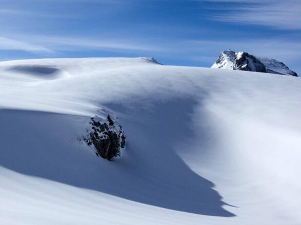 Die markante Haidachstellwand ragt über Schneeverwehungen hervor.