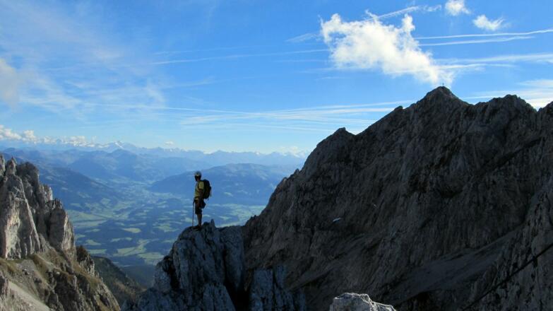 Ein Kletterer auf dem Christaturm, weit oberhalb des Ellmauer Tors und der Gruttenhütte.
