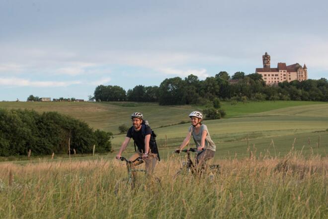 Radler vor der Kulisse der Ronneburg