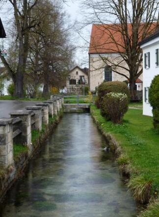 Überquerung des Hungerbachs in Huglfing nahe der Pfarrkirche St. Magnus.