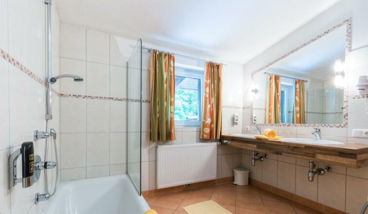 Badezimmer mit Doppelwaschbecken und Badewanne
