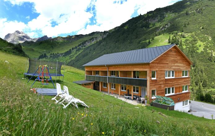 Haus mit Spielplatz und Grillplatz im Hintergrund