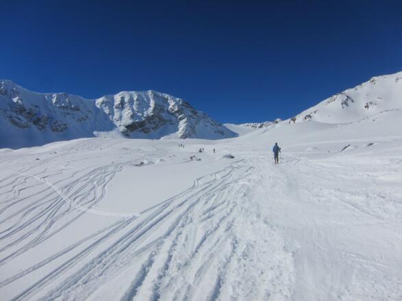 in mehreren flachen Stufen höher auf den bereits sichtbaren Gipfel zu.