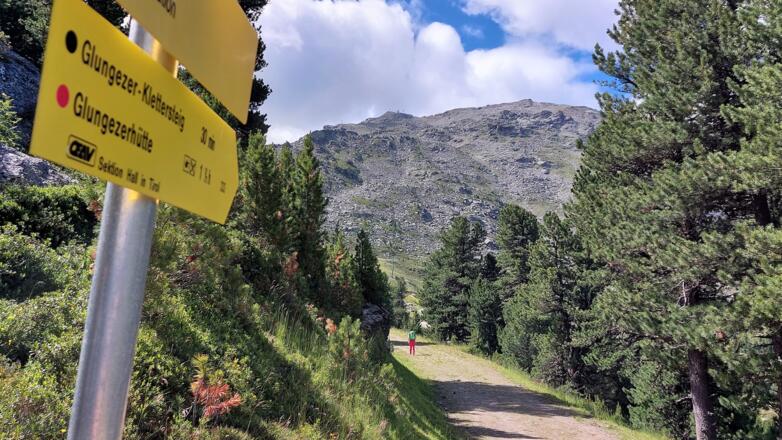 Der Weg zum Einstieg ist mit 30 min angeschrieben. Hinten der mächtige Südhang des Glungezers durch den der Klettersteig verläuft.