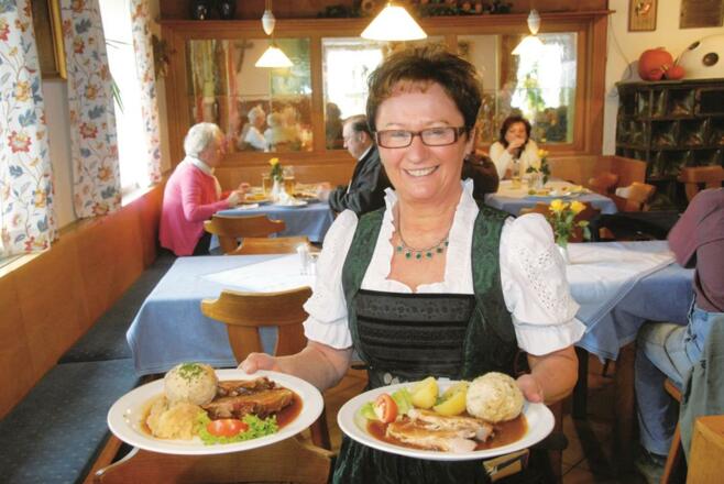 Schweinsbratn serviert von der Wirtin
