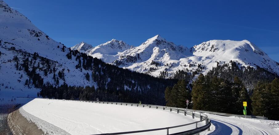 Start über die Staumauer entlang der Loipe. Im Hintegrund (v.l.n.r.): Wörgegratspitz (2722 m), Hintere Karlsspitz (2630 m), Vordere Karlsspitz (2569 m), Schafzoll (2394 m).