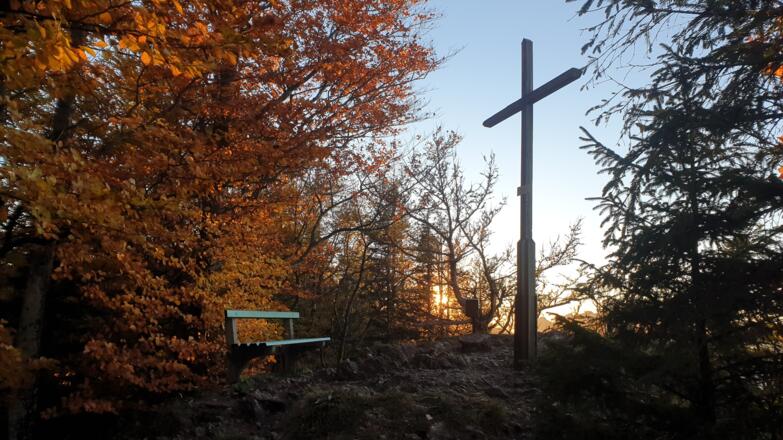 Gipfelkreuz der Hohen Dirn in der Abendsonne im Herbst.