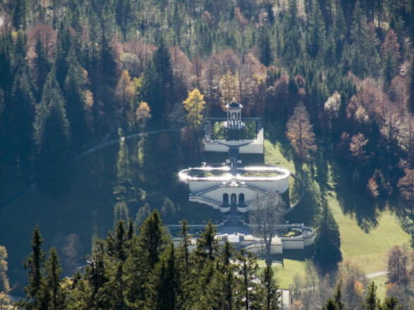 Tiefblick vom Gipfel mit dem Teleobjektiv auf den Park von Schloss Linderhof