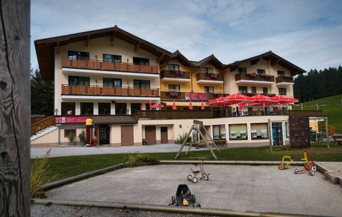 Hausansicht Sommer mit Spielplatz