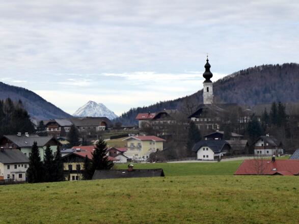 Über den Kirchenweg schließt sich die Runde in Faistenau mit dem Hohen Staufen im Hintergrund.