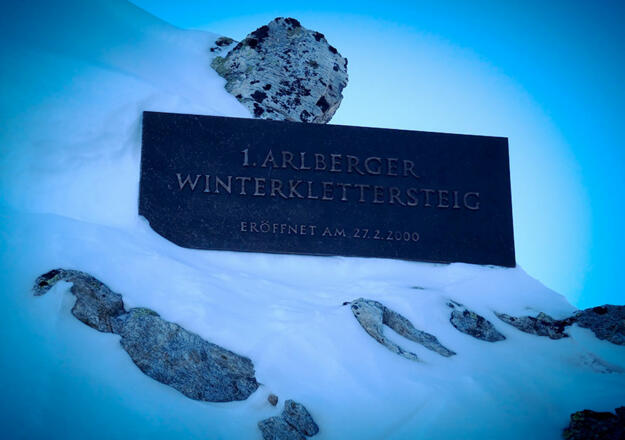 Direkt neben der Station der Riffelbahn II markiert ein Metallschild den Einstieg zum Arlberger Winterklettersteig.