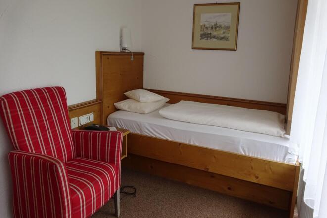 Schlafbereich Einzelzimmer mit Bett und Sessel