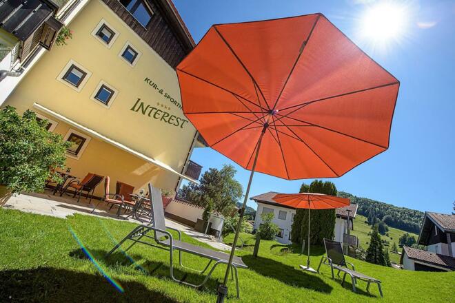 Garten mit Sonnenliegen und Sonnenschirmen