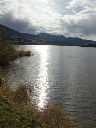 Die tief stehende Novembersonne spiegelt sich im See.