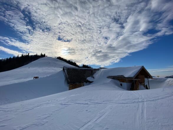 Oft lagert sich der vom Nord/Westwind abgeblasene Schnee hinter den Almhütten ab.