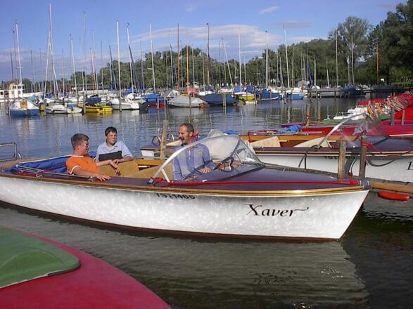 Elektroboot des Chiemsee Bootsverleihs bei der Hafeneinfahrt.