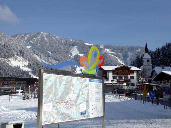 Auf der Info-Tafel mit den eingezeichneten Loipen und Winterwanderwegen hat sich der Schmetterling niedergelassen.