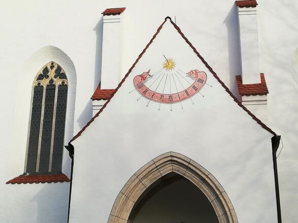 Sonnenuhr über dem Eingangsportal der St. Georgs Kirche