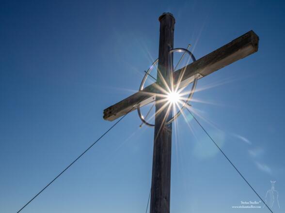Sonnenstern im Kreis des Gipfelkreuzes.