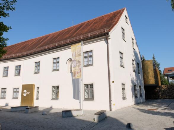 Historische Fassade des ehem. Antoniusheims neben moderner Goldschindelfassade des Neubaus.