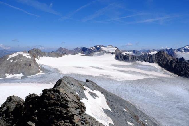Blick zurück vom Gipfel mit Brandenburger Haus auf dem Felssporn links, dem Kesselwandjoch, dem Kesselwandferner und dem Fluchtkogel (3500m) zentral am Horizont
