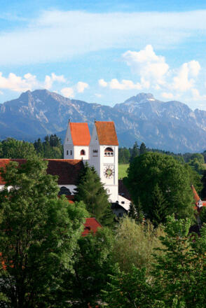 Das Welfenmünster in Steingaden mit der Alpenkette im Hintergrund