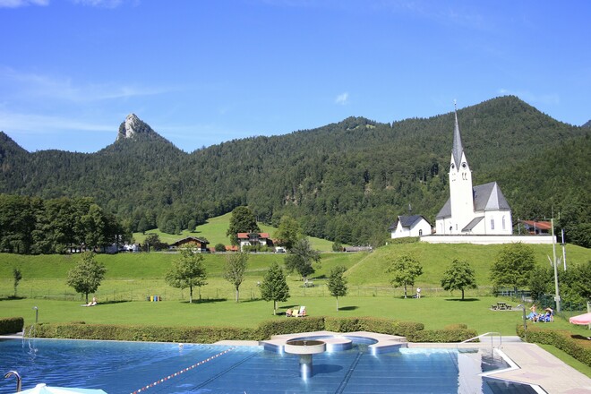 Warmfreibad Kreuth mit Kirche St. Leonhard und Leonhardstein