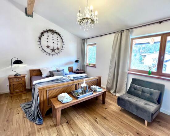 Eine Nachttischlampe mit USB-Buchse,  ein Kristall-Leuchter  und ein Kleiderschrank gehören zu diesem Wohlfühl-Schlafzimmer