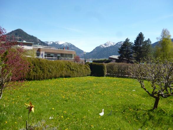 Ausblick von den Ferienwohnungen mit Garten, zur Vitalwelt, mit Schwimmbad, Sauna, Restaurant und die umliegenden Schlierseer Berge