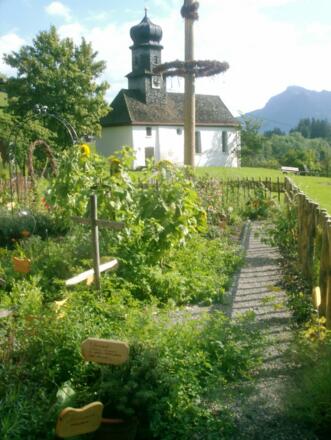 Kräutergarten mit Kapelle im Hintergrund