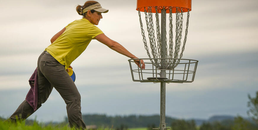 Frau spielt Discgolf