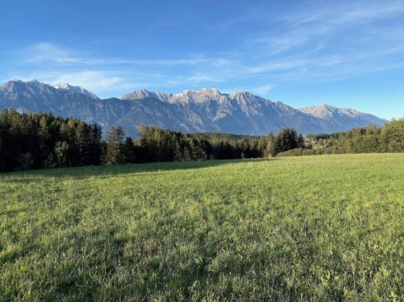 Bei der Auffahrt in Richtung Aldranser Alm schweift der Blick hinüber zu den Felsbergen des Karwendels.