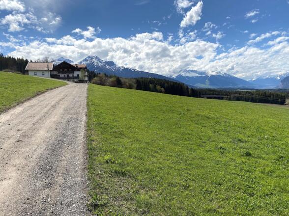 Von Sistrans führt der Perchegg-Weg durch Felder in Richtung Lans.
