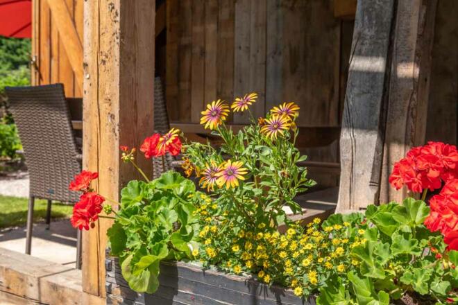 Ferienhaus Naschgarten in Bad Goisern mit Sitzbereich und Blumen