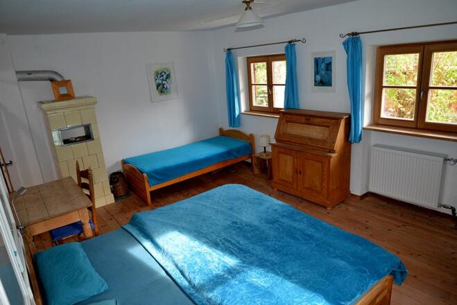 Großes Schlafzimmer im Erdgeschoß mit einem Doppelbett und einem Einzelbett.