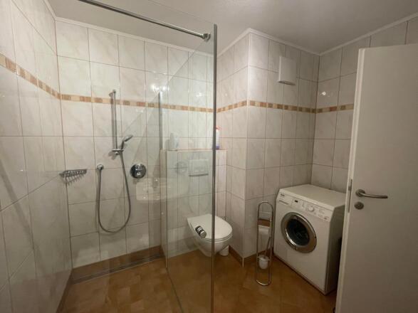 Badezimmer mit WC und Waschmaschine