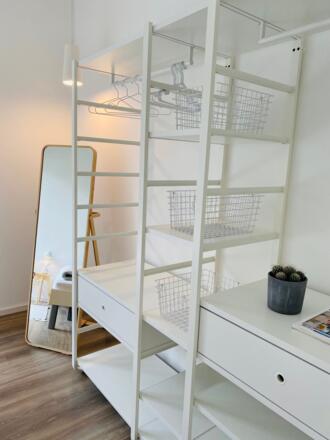 Schlafzimmer mit Spiegel und offene Ablage für die Kleidung