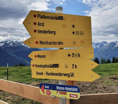 Unterhalb der Venetalm weist eine Tafel u.a. nach Plattenrain. Darunter auch das MB-Schild "Wenns-Venetalm", dem man nun folgt.