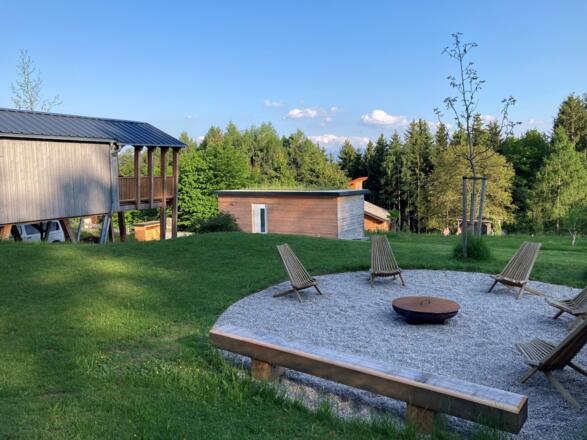 Garten mit Feuerstelle und Blick aufs Haus