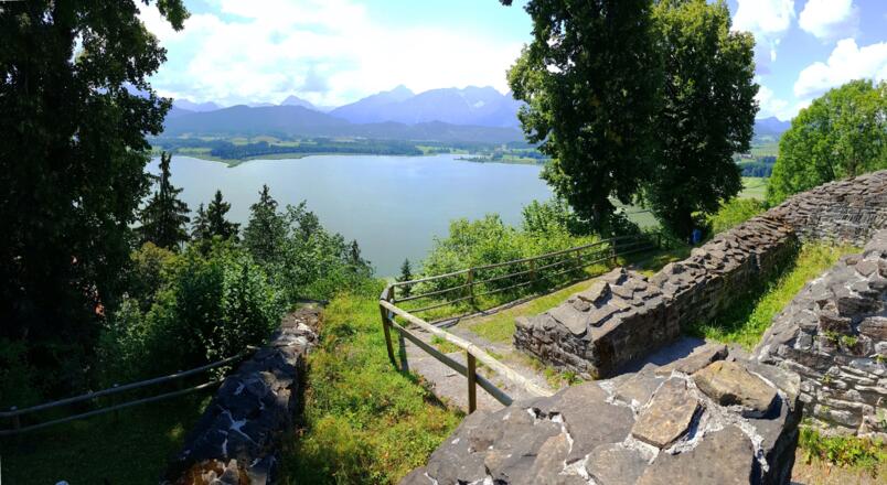 Blick von der Burgruine Hopfen über den See hinweg zu den Tannheimer Bergen und den Ammergauer Alpen