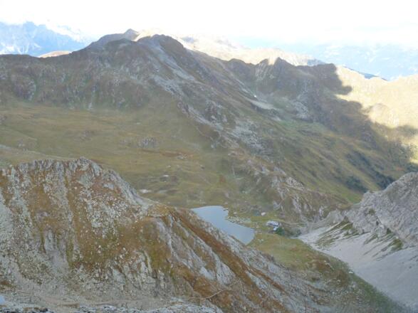 Tiefblick vom Gipfel zur Obstanser Seehütte, wo man auch den Steig gut erkennt.