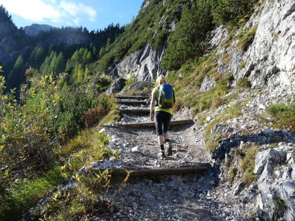 Ein schön angelegter Steig mit zahlreichen Holzstufen führt uns durch die Felswände zu den Obstanser Wiesen.