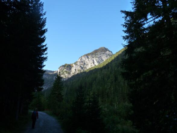 Während wir noch im Schatten wandern, erstrahlt die Gatterspitze bereits im Sonnenlicht.