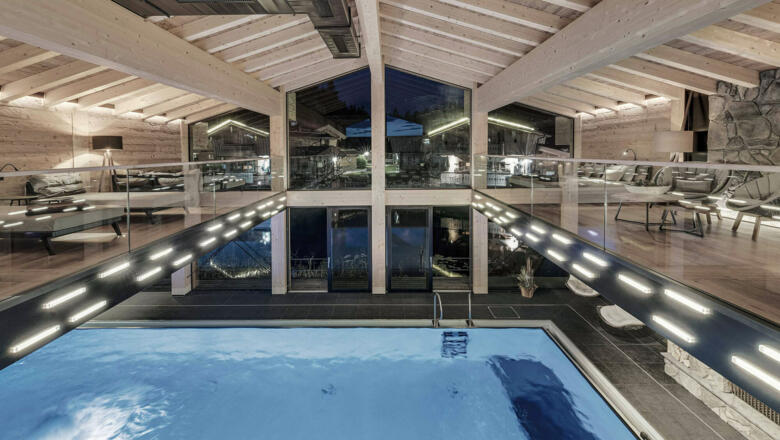 INNs HOLZ Chaletdorf | Vitaloase mit Indoorpool und Waldblick-Panoramalounge bei Nacht