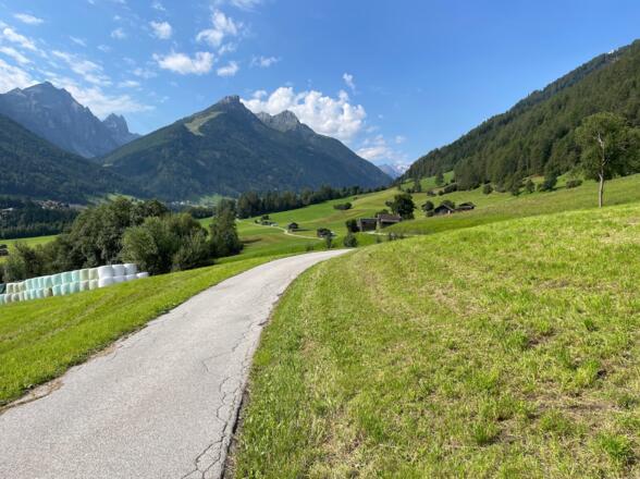 Erhöht über dem Stubaital führt der Radweg durch Wiesen und Felder und vorbei an Heustadl in Richtung Neustift i. St.