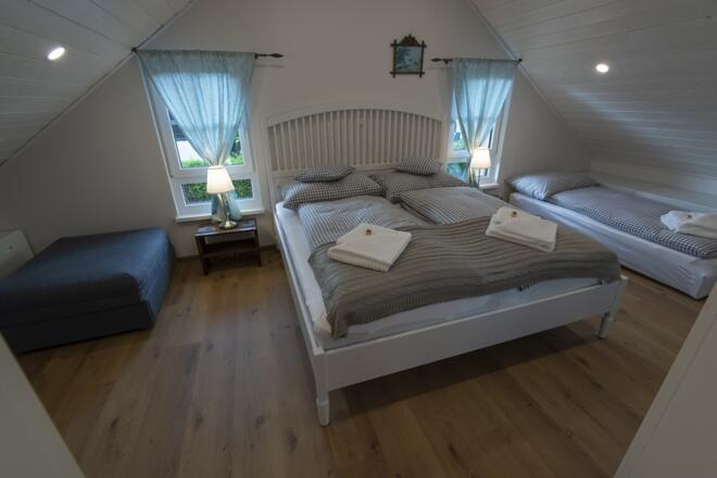 Mansardenschlafzimmer mit Doppelbett und zwei Einzelbetten