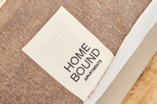 Homebound Apartments Bad Goisern-Logo am Bett