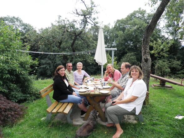 Eltern treffen sich beim Brunnen im Garten