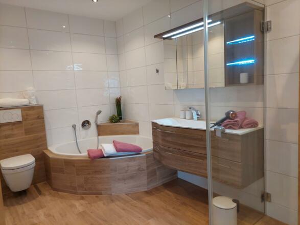 Badezimmer mit Eckbadewanne, WC und Dusche